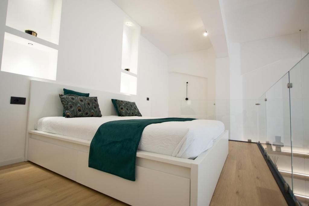 米兰Loft Milano Manifatture2的白色卧室配有白色床和绿毯