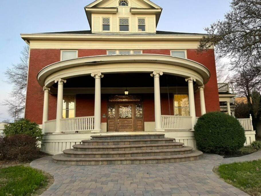 IrontonOakridge House. Spacious and historic home in downtown Ironton, Ohio.的一座红色的大房子,设有大门和楼梯