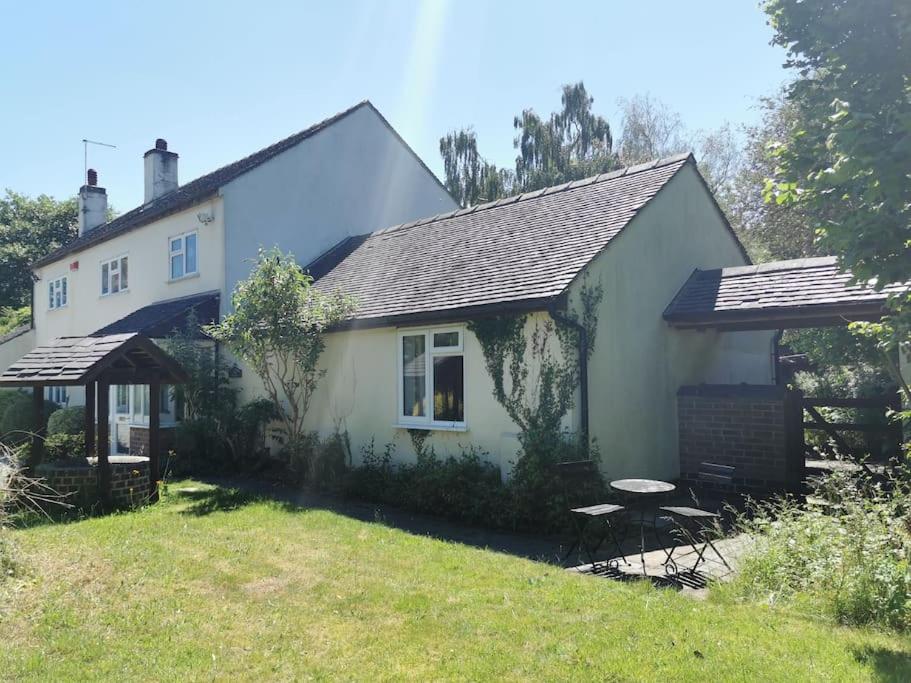 巴顿尼德伍的Canalside Cottage的前面有一张野餐桌的白色房子