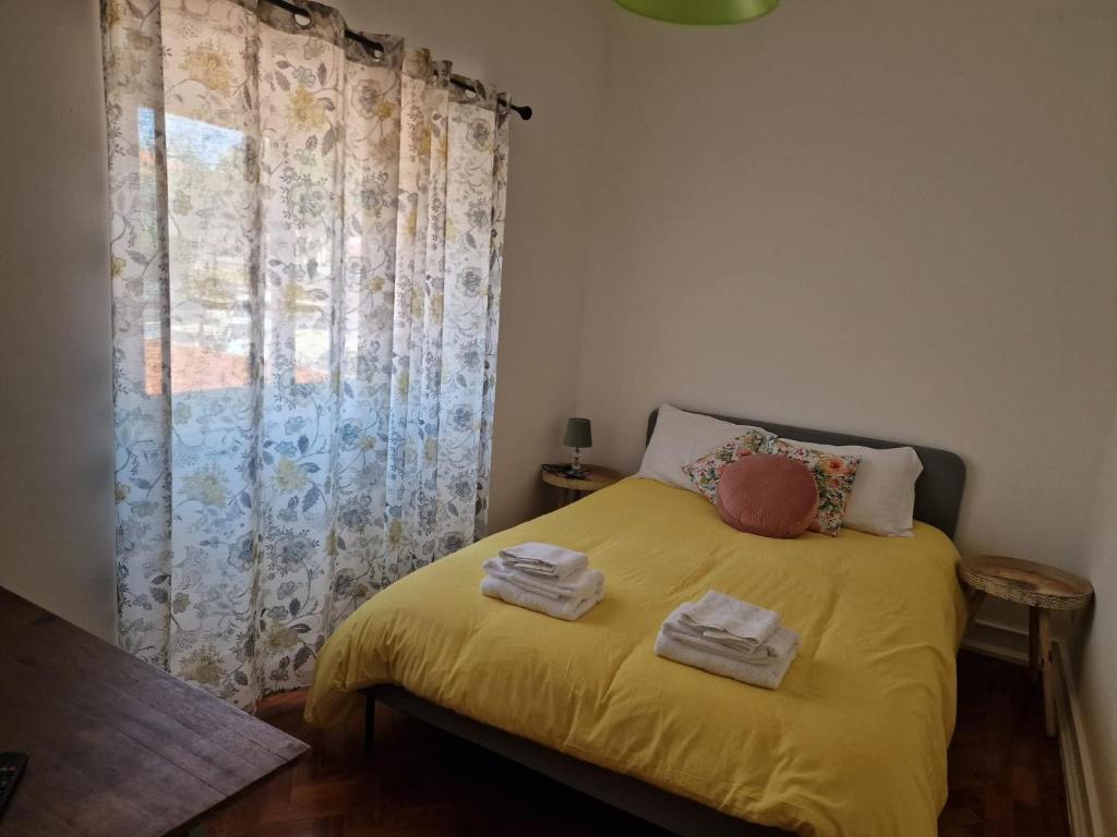 里斯本Alojamento Mercado Norte的一间卧室配有黄色的床和毛巾