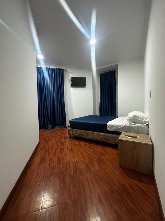 波哥大Hotel Artistico的客房设有一张床,铺有木地板。