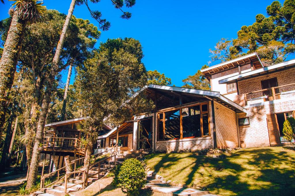 坎波斯杜若尔当Pousada Villa Serena的享有树木房屋的外部景色