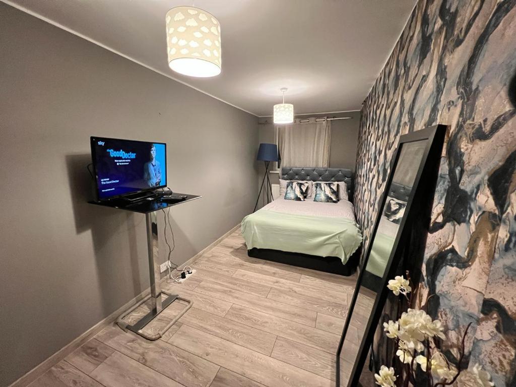 罗金厄姆Comfy double room in Corby的一间卧室配有一张床和一台电视。