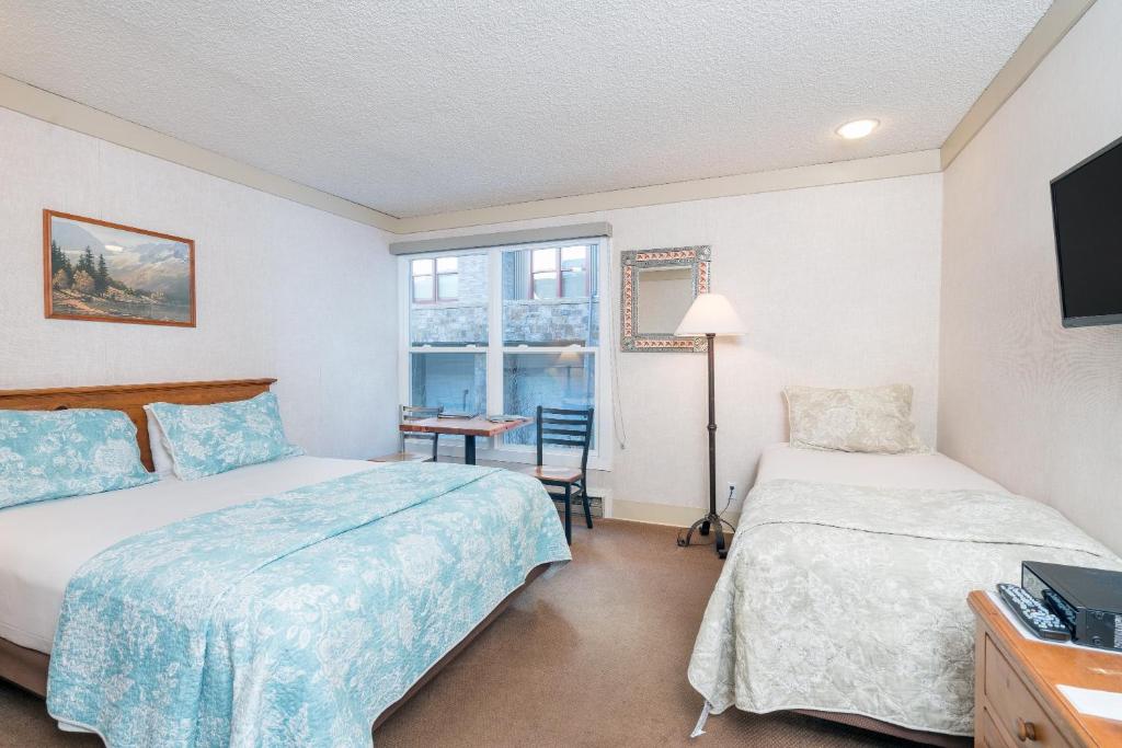特柳赖德Mountainside Inn 301 Hotel Room的酒店客房设有两张床和窗户。