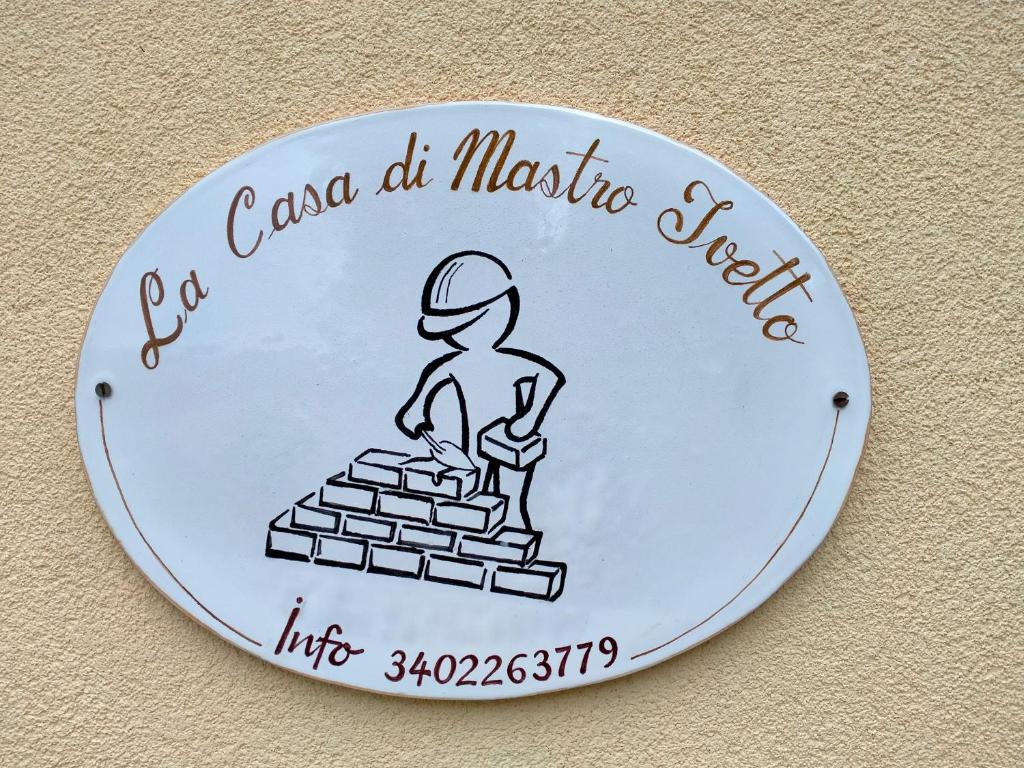 ArceviaLa casa di Mastro Ivetto的一堆砖头上的人的标志