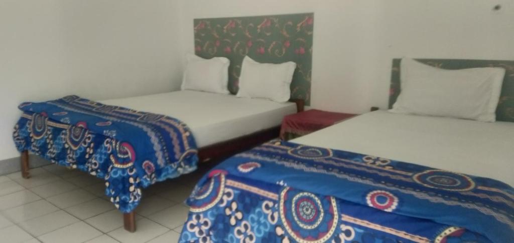 克里穆图Hidayah homestay的配有两张床和床边的房间