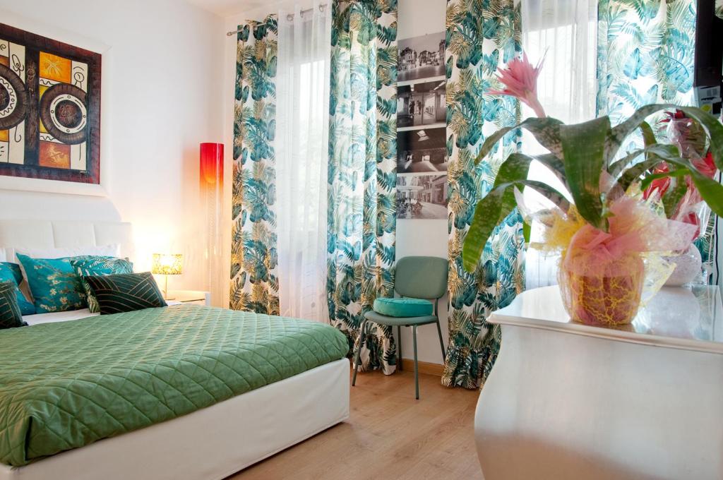 维罗纳Arena d'Intorno的一间卧室配有绿色的床和植物