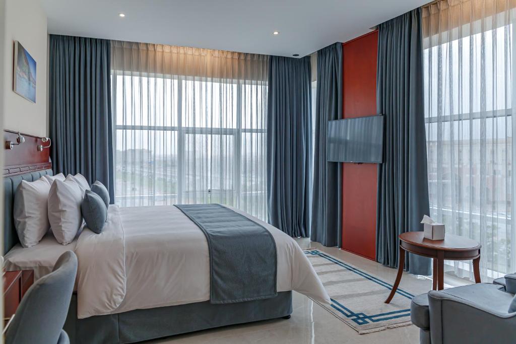 塞拉莱Salalah International Hotel的一间卧室设有一张大床和一个大窗户