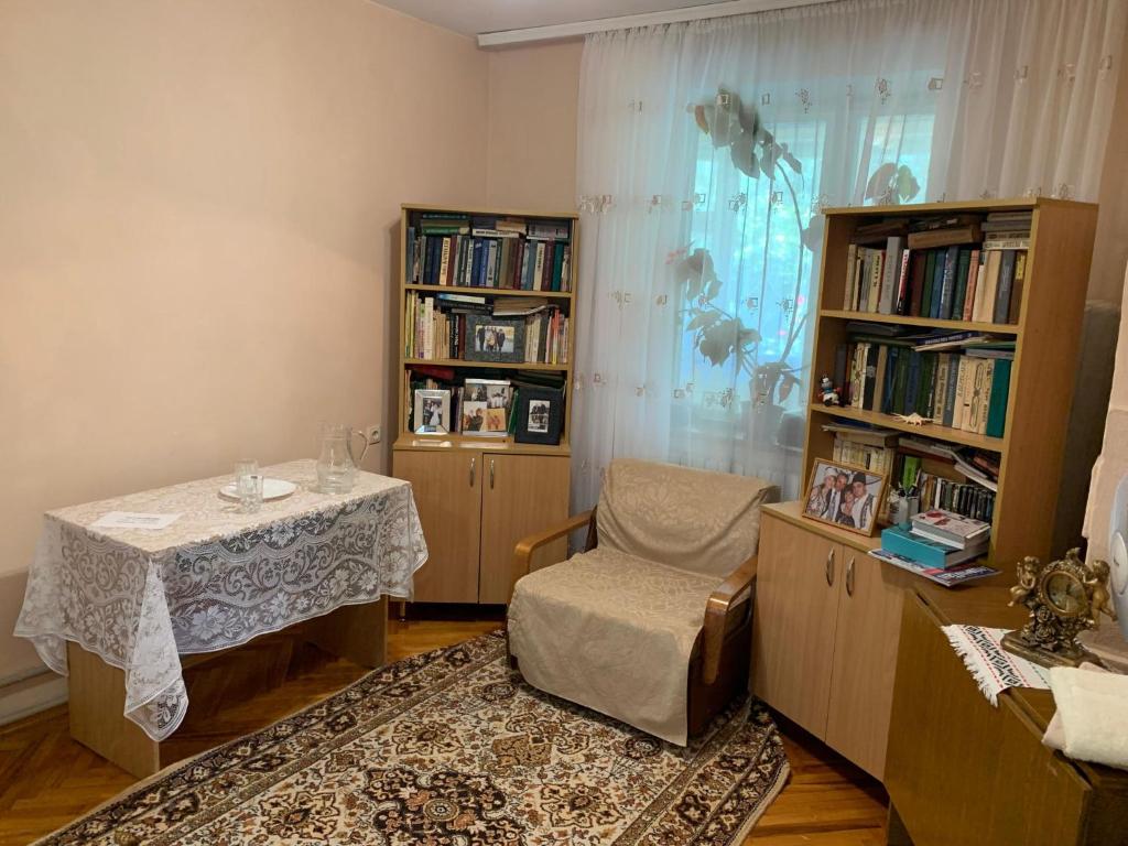 BîcVila Tatiana的一间设有桌子、椅子和书架的房间
