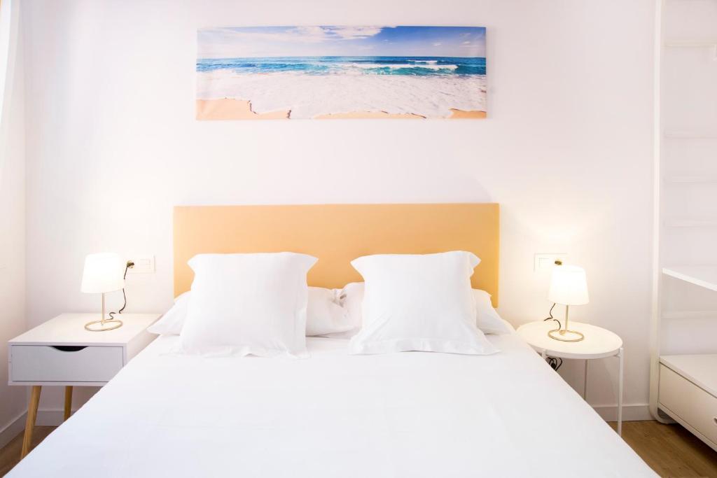 格罗韦P4 O Grove Centro Puerto的卧室配有带两盏灯的白色床