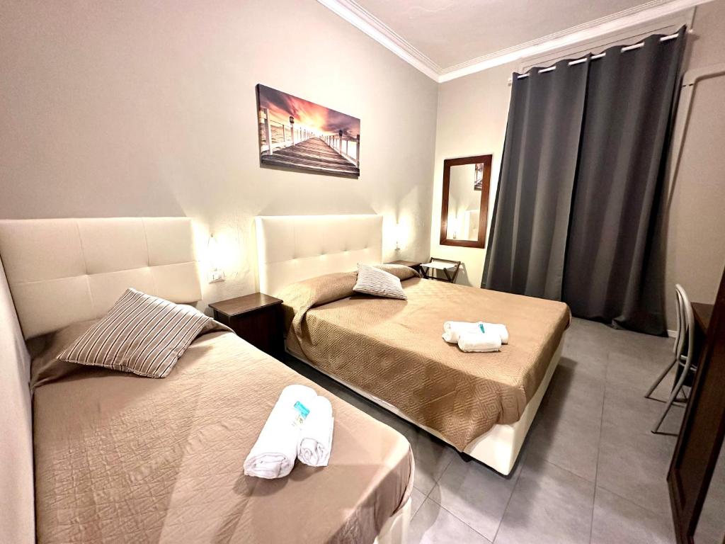 米兰Carlo Goldoni Hotel的两张位于酒店客房的床,配有毛巾