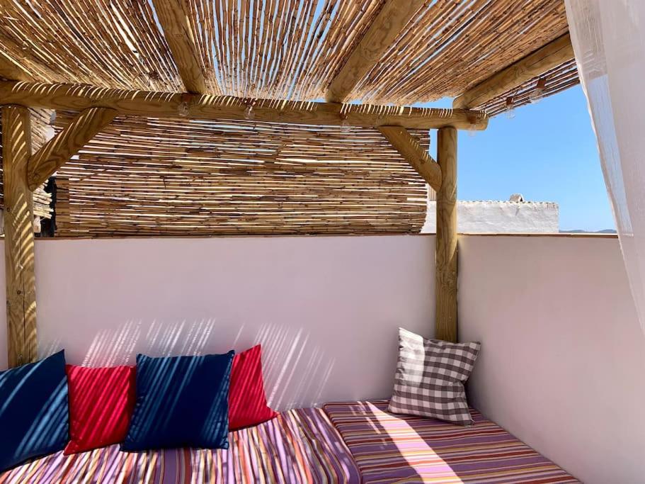 Canillas de AceitunoTownhouse in Canillas de Aceituno的客房设有一张带色彩缤纷枕头的床。