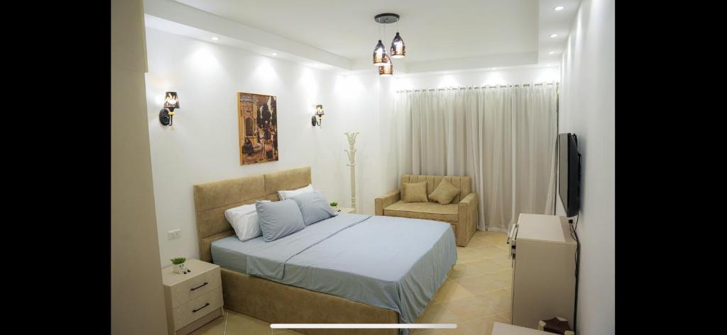 赫尔格达Binishty hurghada apartment的一间卧室配有一张床、一把椅子和电视