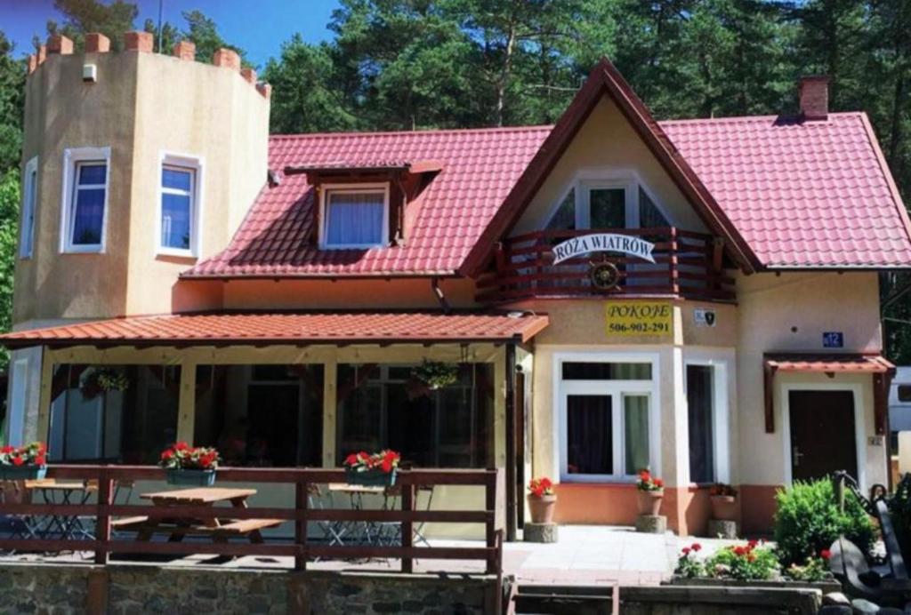 斯图托沃Róża Wiatrów的一座带红色屋顶和野餐桌的房子