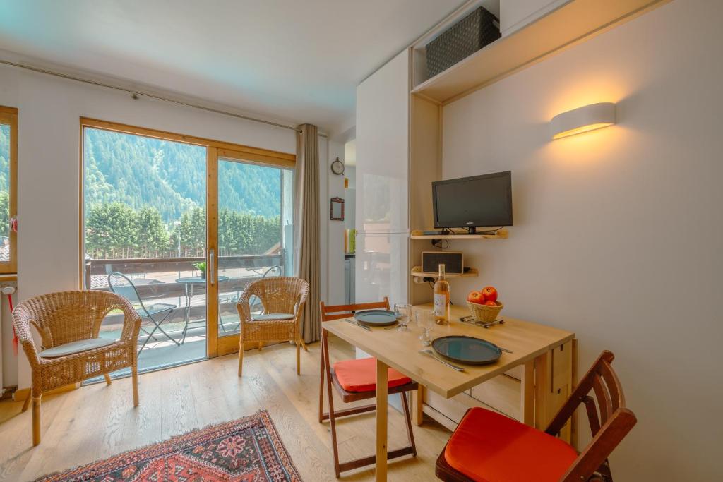 夏蒙尼-勃朗峰Les Marmottes d'Argentière - Happy Rentals的客厅配有桌椅和大窗户