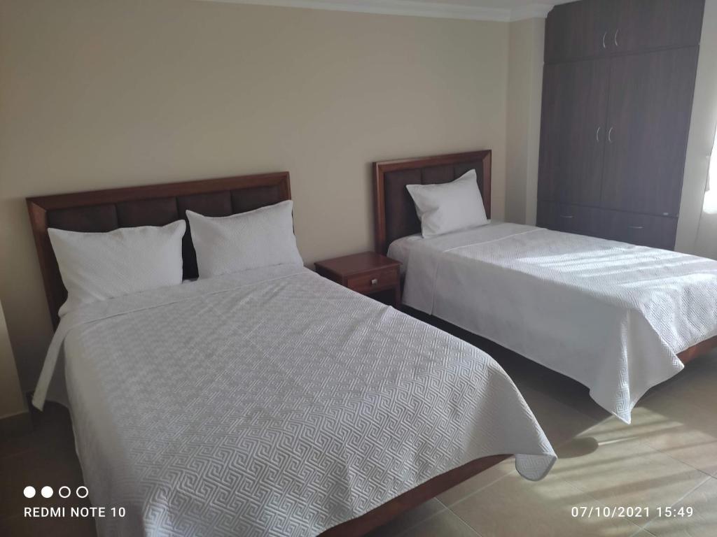 伊瓦拉HOTEL SHANGHAI CITY的卧室内两张并排的床