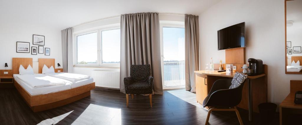 埃默里希Hotel Rheinpromenade8的配有一张床和一张书桌的酒店客房
