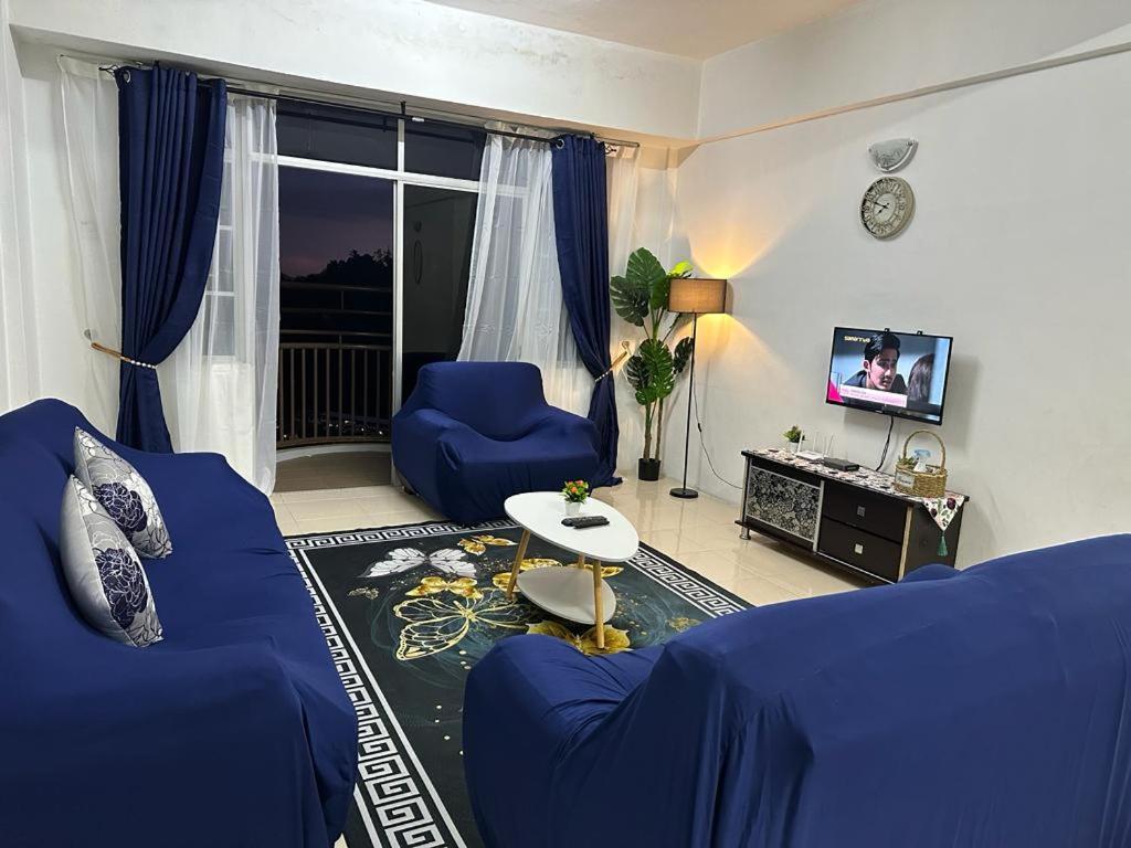 伯恩仓D'CAMERON MUSLIM HOMESTAY的客厅配有蓝色的沙发和电视