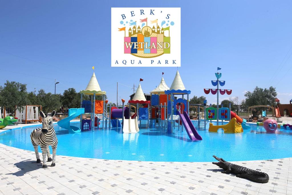 艾瓦勒克Simlarda Country Club Ayvalık的斑马站在水上公园前
