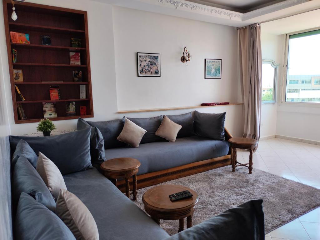 拉巴特Élégant appartement 3 chambres的客厅配有蓝色的沙发和桌子