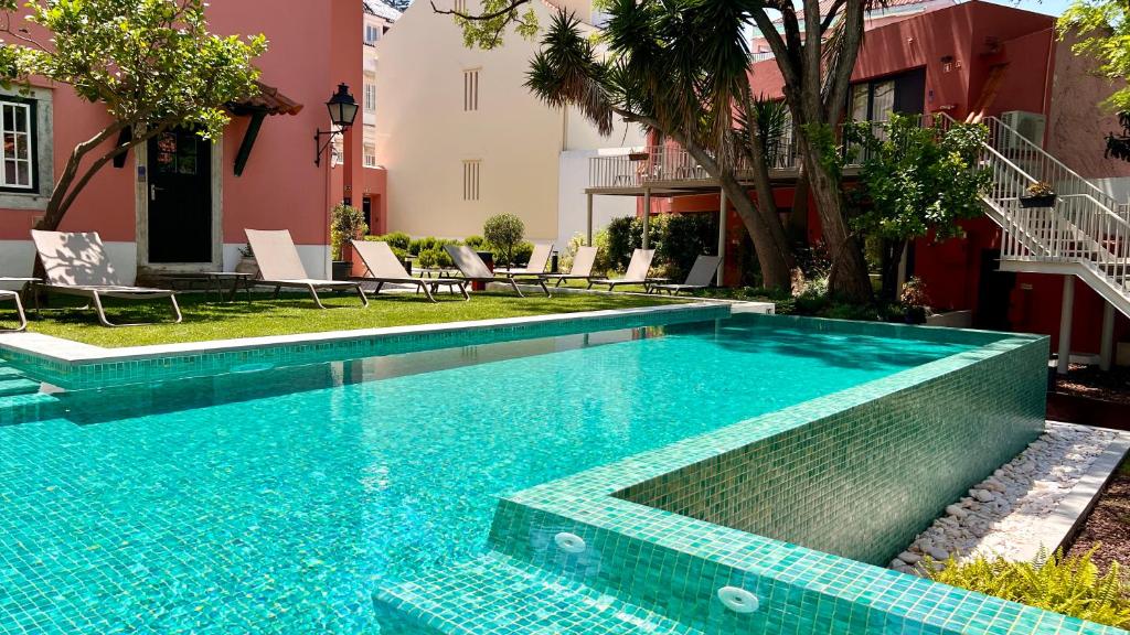 里斯本Jardim da Lapa by Shiadu的庭院内一个蓝色瓷砖的游泳池