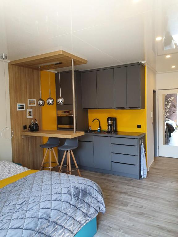 诺德奈Kleine Milchbar的一间卧室配有床,厨房拥有黄色的墙壁