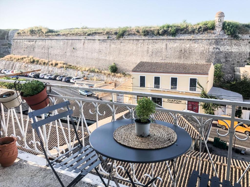 Ágios RókkosCorfu Fortress Apartment的阳台上的桌子上放着盆栽植物