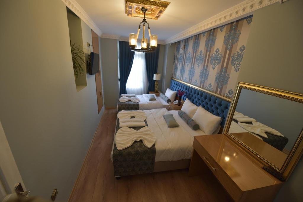 伊斯坦布尔GOLDEN PALACE SEA ViEW的酒店客房,设有两张床和镜子