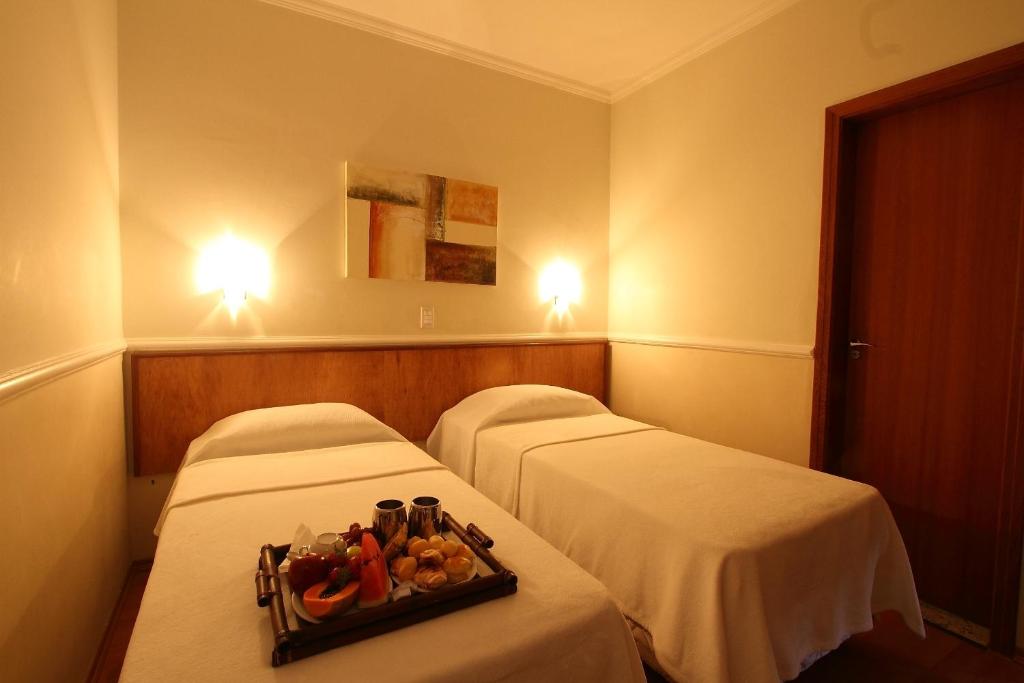索罗卡巴Scarpelli Palace Hotel的配有两张床铺的酒店客房,提供水果盘