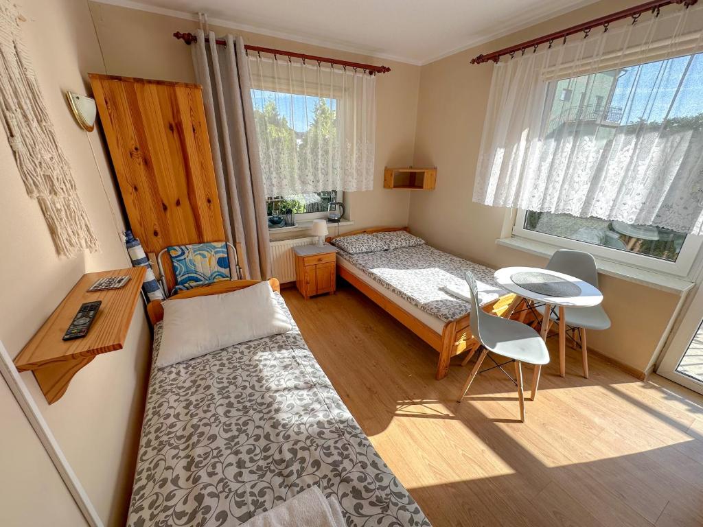 弗瓦迪斯瓦沃沃Joasia的一间小卧室,配有一张床、一张桌子和一张桌子