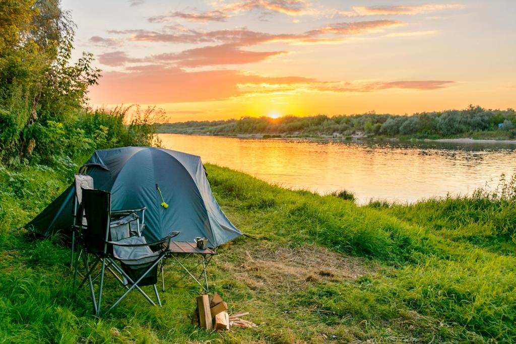 普伦盖A&G Sodyba camp ąžuolų pavėsyje的日落时分在河岸上的帐篷