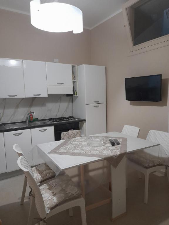 巴列塔Casa del sole的厨房配有白色的桌子和白色的橱柜。