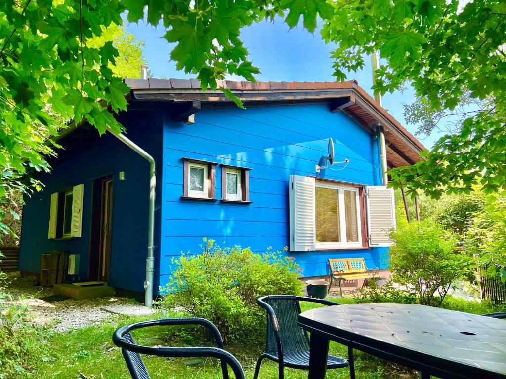 圣安德里斯伯格Platell Ferienhausverwaltung Sankt Andreasberg的蓝色房子前面有一张桌子