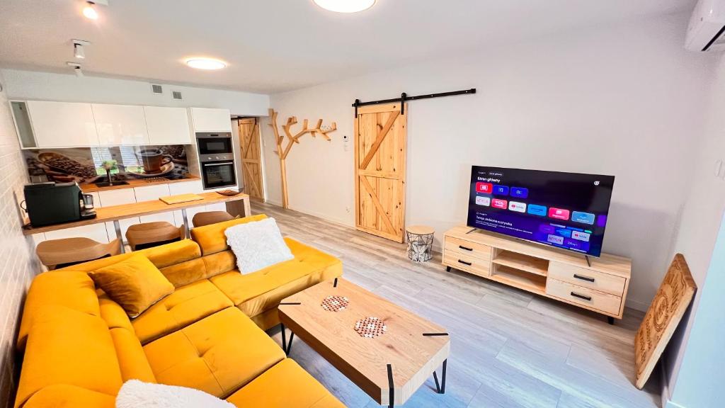 哈日科维CHARZYKOWSKIE TARASY的客厅配有黄色沙发和平面电视。