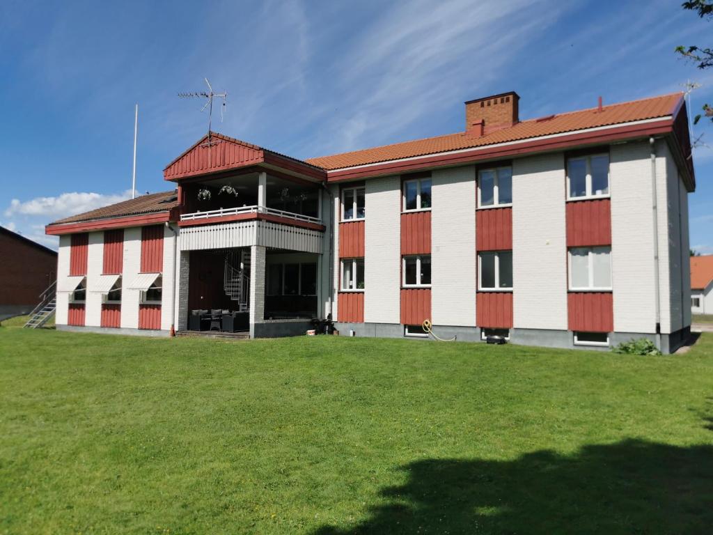 莫拉Saxvikens vandrarhem的一座红色和白色的建筑,有草地庭院