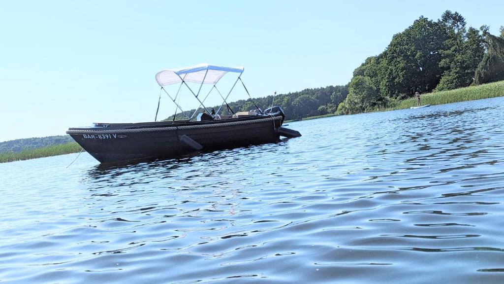 菲尔斯滕贝格Waterview - Schwimmendes Ferienhaus auf dem Wasser mit Blick zur Havel, inkl Motorboot zur Nutzung的湖上黑船