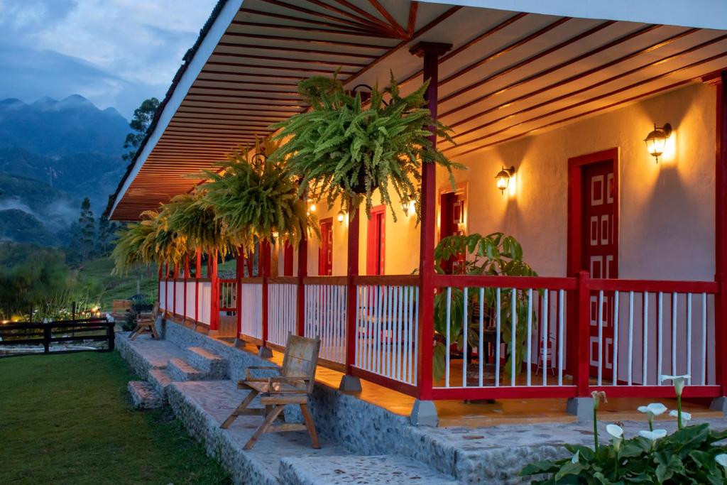 圣罗莎德卡瓦尔Hotel Rural SAN REMO的一座棕榈树的红色和白色门廊