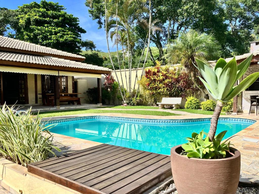 圣塞巴斯蒂安Casa de temporada estilo rústico - Litoral Norte de SP的棕榈树花园中的游泳池
