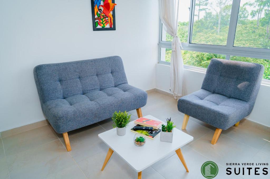 阿帕尔塔多Sierra Verde Living的客厅配有两把椅子和一张茶几