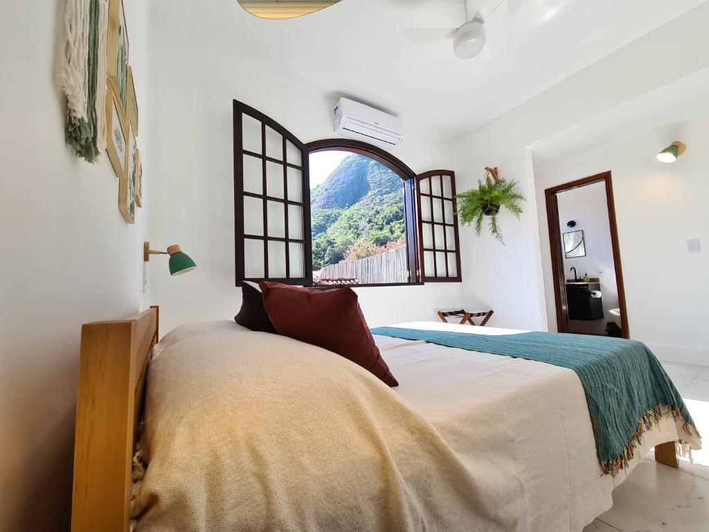 尼泰罗伊Itacoatiara - Apartamento com café da manhã ao lado da praia的一间卧室设有一张大床和一个窗户。