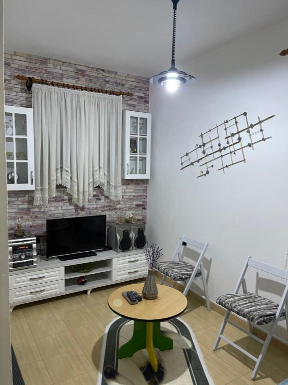 斯库台Dibra Home near City Center of Shkodra的客厅配有电视和桌椅