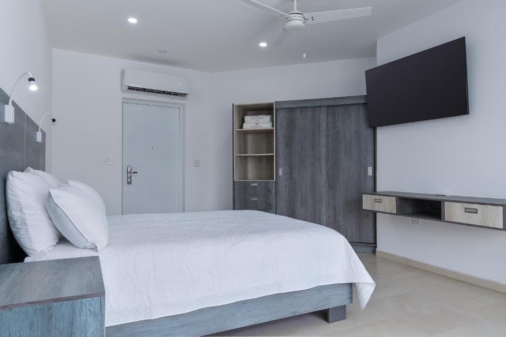 圣克鲁斯华特库Casa Xtao Hotel的一间卧室配有一张床和一台平面电视