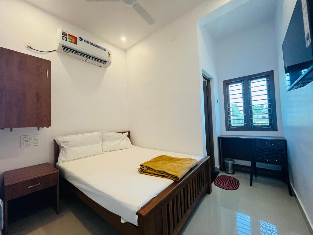 蒂鲁琴杜尔SRI BALAJI LODGING的一间小卧室,配有床和窗户
