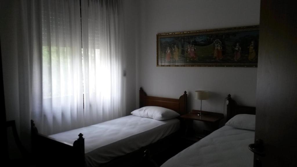 罗韦雷托Casa Betulla的小型客房 - 带2张床和窗户