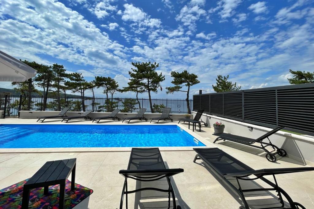 希洛Villas Punta Silo - luxury apartments with pool的一个带躺椅的游泳池和一个游泳池