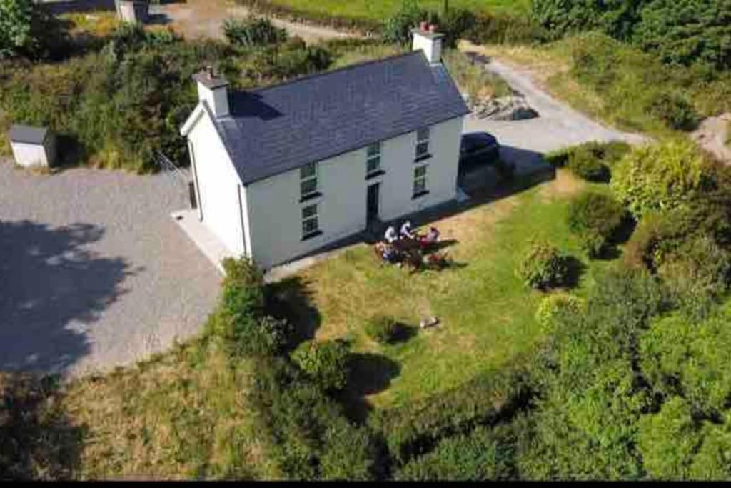 斯奇博瑞恩Idyllic Family farmhouse in beautiful West Cork的白色房屋的空中景致,设有绿色百叶窗