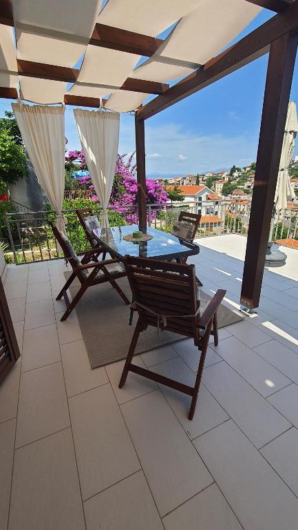 斯托莫斯卡Apartments with sea view的露台上的桌椅和遮阳伞