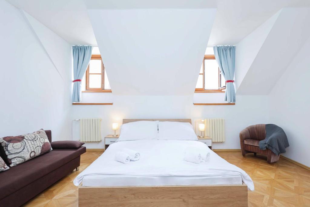 布拉迪斯拉发Beethoven Apartments的一间卧室配有一张床、一张沙发和窗户。
