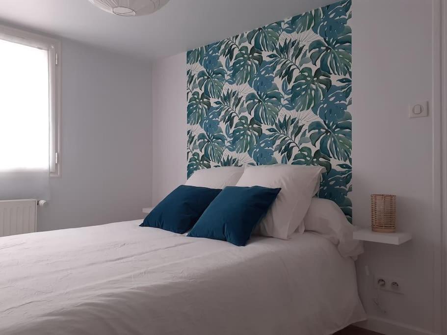 康博莱班Appartement neuf et cosy的一间卧室配有白色床和蓝色枕头