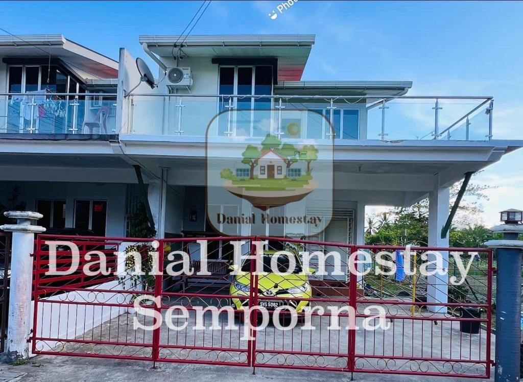 仙本那Danial Homestay Semporna的红栅栏后面有标志的建筑物